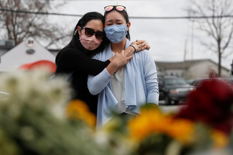 Helen Park Truong, 34, and Sarah Tang, 31, embrace after laying flowers at a makeshift memorial outside the Gold Spa, following the deadly shootings in Atlanta, Georgia, US. Reuters