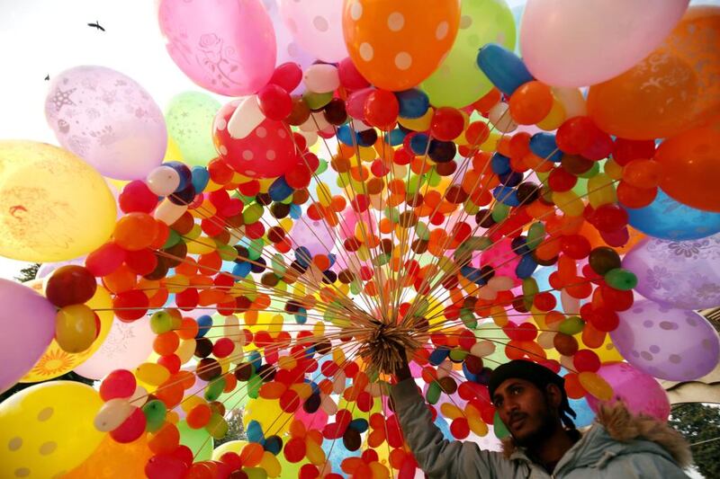 A street vendor offers a bunch of colourful balloons for sale on New Year’s Eve in a public garden in Amritsar, India. Raminder Pal Singh / EPA