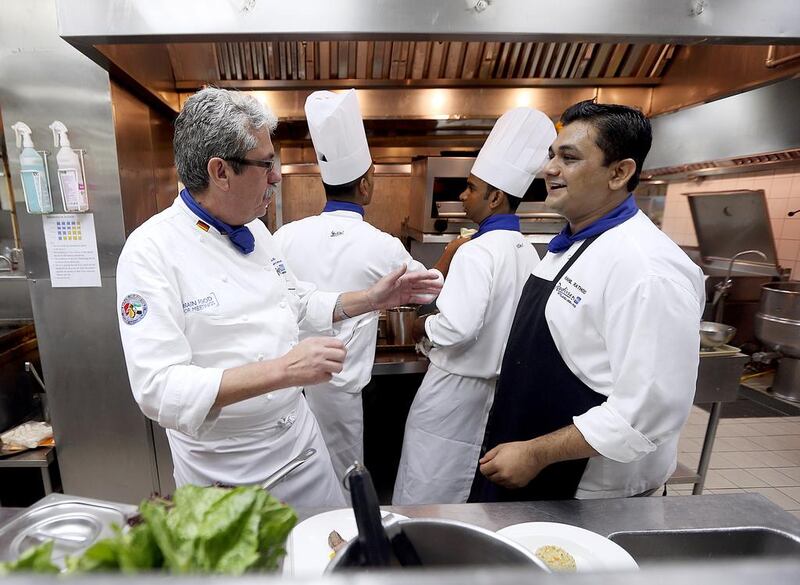 Uwe Micheel, left, gives chef Rahil Rathod instructions. Satish Kumar / The National