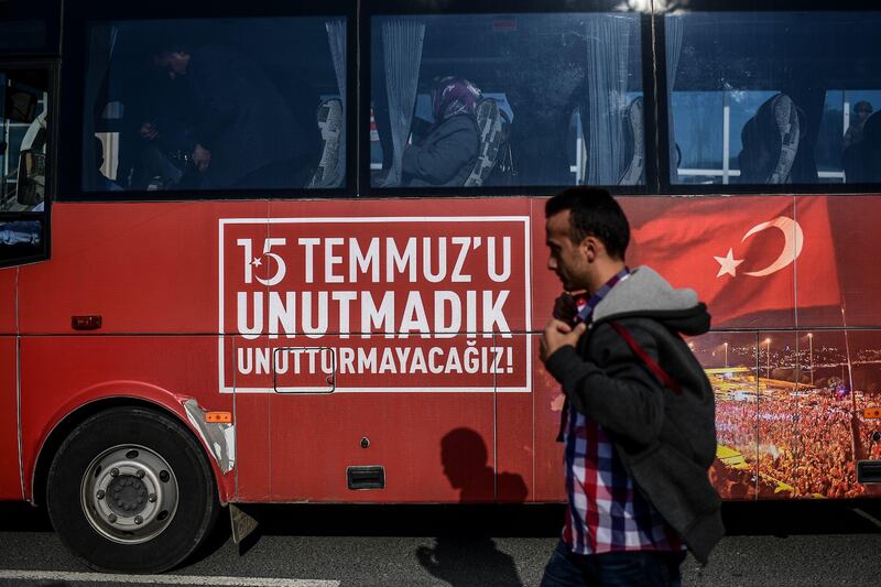 A man passes by a bus with a message reading "We do not forget July 15"  by the Silivri prison courthouse, in Istanbul, on October 9, 2017, during a trial of 143 soldiers accused of causing the deaths of 34 people on Istanbul's first Bosphorus bridge on the night of last year's failed coup.
Almost 150 former Turkish military personnel go on trial Monday over clashes on an Istanbul bridge during last year's failed coup that claimed dozens of lives including a key aide of President Recep Tayyip Erdogan. The bridge across the Bosphorus strait in Istanbul was the scene of bloody fighting between Erdogan's supporters and renegade soldiers seeking to oust the elected government on the night of July 15, 2016. / AFP PHOTO / OZAN KOSE