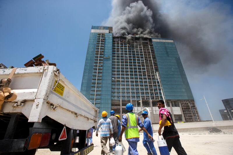 Abu Dhabi, United Arab Emirates, August 30, 2016:    Evacuated workers watch emergency crews respond to a fire at a building under construction next to the Beach Rotana Hotel in the Tourist Club area of Abu Dhabi on August 30, 2016. Christopher Pike / The National

Job ID: 
Reporter:  N/A
Section: News
Keywords:  *** Local Caption ***  CP0830-na-fire13.JPG