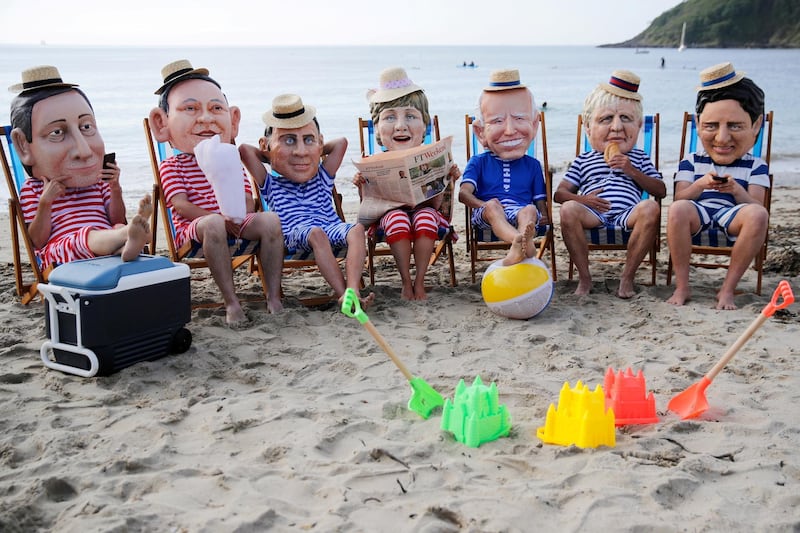 Oxfam activists wearing papier mache heads depicting G7 leaders. Reuters