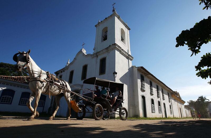 PARATY, BRAZIL - MARCH 14:  A horse pulls a carriage in the historic center of town on March 14, 2014 in Paraty, Brazil. Paraty was built as a Portuguese colonial town shortly after Portugal colonized Brazil in 1500. Paraty flourished during the 18th Century as the main port to ship Brazilian gold to Portugal. The town fell by the wayside and was only re-discovered by travelers in the mid 20th Century, its historic center is well preserved and the cobblestone streets remain closed to automobiles.  (Photo by Mario Tama/Getty Images)