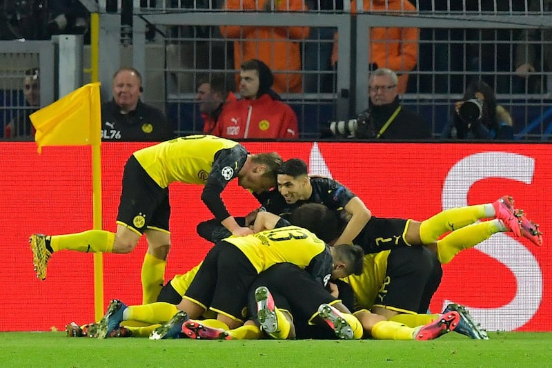 Dortmund's players pile on Erling Haaland after he restored their lead. AFP