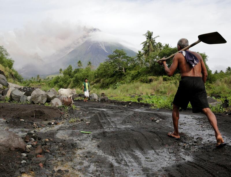 Filipino villagers walk along the slopes of rumbling Mayon Volcano as it spews ash in Legaspi city, Albay province, Philippines. Francis R. Malasig / EPA