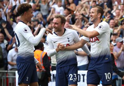 Tottenham Hotspur's Harry Kane, right, celebrates scoring his side's third goal of the game against Fulham, with team-mates Christian Eriksen, centre, and Dele Alli, during the English Premier League soccer match at Wembley Stadium in London, Saturday Aug. 18, 2018. After 15 games and more than 1,000 minutes, Harry Kane has finally scored a Premier League goal.  (Nick Potts/PA via AP)