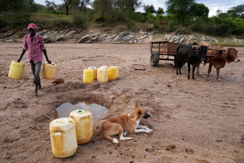 Drawing water from a hole in a sandy riverbed in Makueni County, Kenya. There have been fatal clashes between clans in the country who dispute each other’s access to water and pasturelands.  AP 