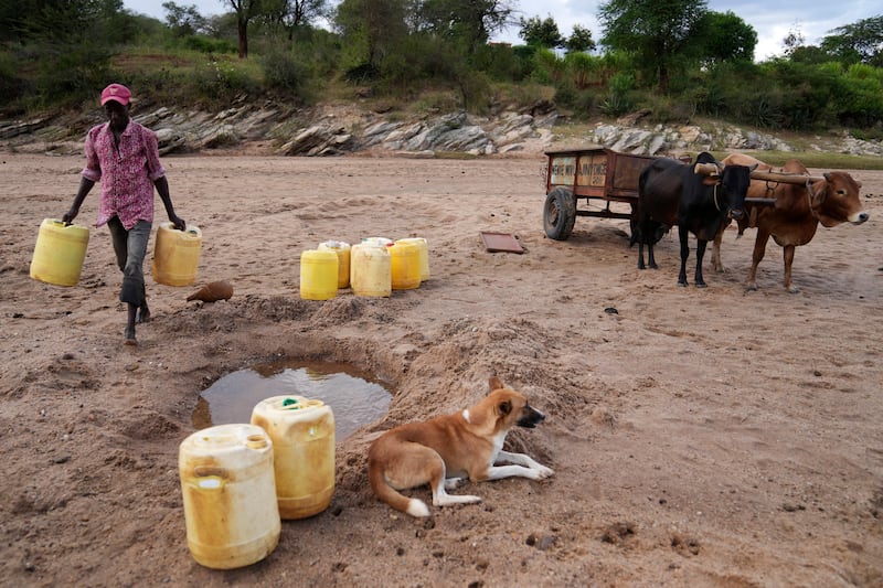 Drawing water from a hole in a sandy riverbed in Makueni County, Kenya. There have been fatal clashes between clans in the country who dispute each other’s access to water and pasturelands.  AP 