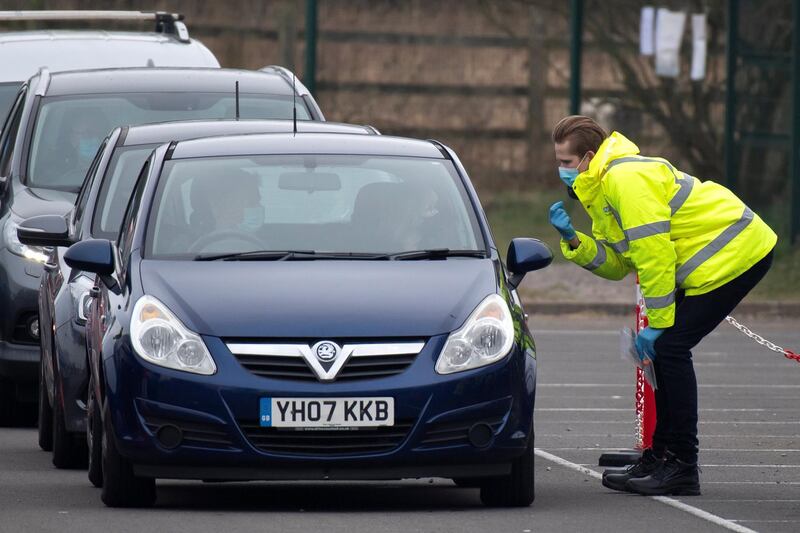 STOKE GIFFORD, ENGLAND - MARCH 1: A member of staff speaks to a passenger of a car at a temporary coronavirus testing centre at Stoke Gifford park and ride on March 1, 2021 in Stoke Gifford, England. Testing efforts were expanded in South Gloucestershire after three returning residents were recently found to have been infected with a Covid-19 variant first discovered in Brazil, which officials worry is more contagious than the dominant Covid-19 strain. Three other travelers to Scotland also tested positive for the Brazil variant. (Photo by Matthew Horwood/Getty Images)
