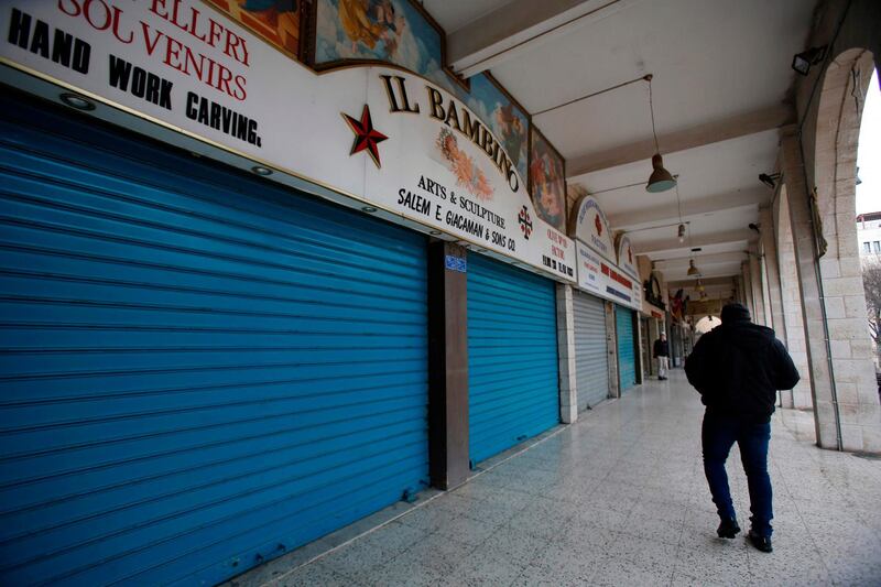 A Palestinian man walks past closed shops in the West Bank city of Bethlehem on March 6, 2020. AFP