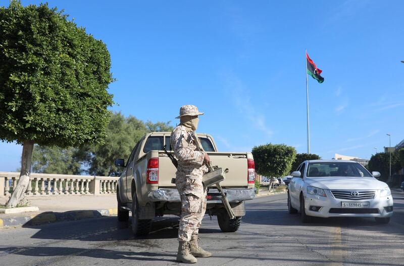 A member of security forces stands near the site of the headquarters of Libya's foreign ministry after suicide attackers hit in Tripoli, Libya. Reuters