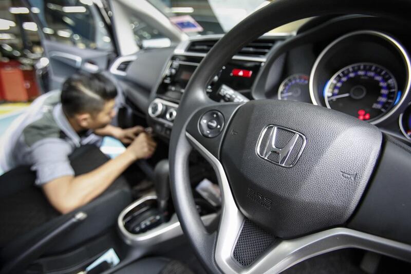 An automotive technician works on a Honda car at a service centre in Kuala Lumpur. A Malaysian woman has died after the airbag in her Honda City ruptured in a minor collision.  Joshua Paul / AP Photo