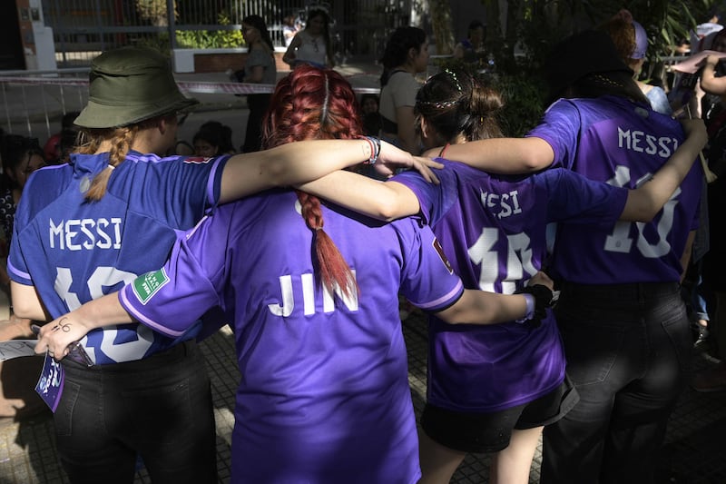 BTS fans wear Argentina's football team shirts, with one specifically for Jin. 