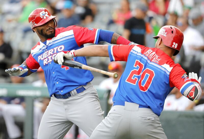 Anthony Garcia, left, of Criollos de Caguas of Puerto Rico celebrates after scoring against Caribes de Anzoategui of Venezuela during the Caribbean Baseball Series at the Charros Jalisco stadium in Guadalajara, Jalisco state. Mexico Ulises Ruiz / AFP