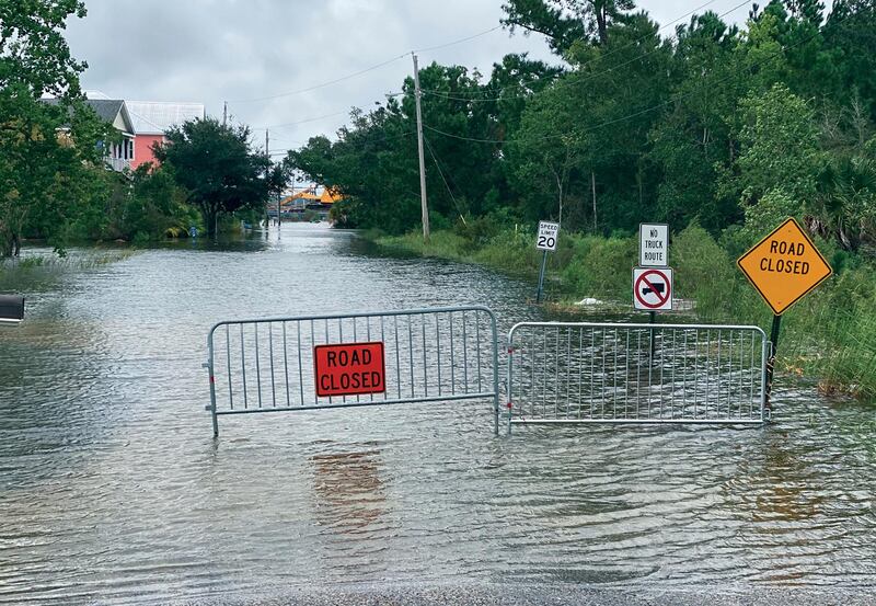 Waters from the Gulf of Mexico, driven by Hurricane Sally, flood this Pass Christian, Mississippi, street and threaten the homes that line it. AP