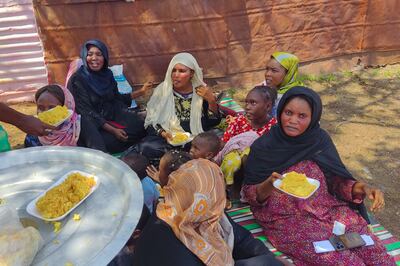 People fleeing the town of Singa, the capital of Sudan's southeastern Sennar state, receive meals distributed by an NGO as they rest in a makeshift camp after arriving in Gedaref in the east of the war-torn country on July 2, 2024. AFP 