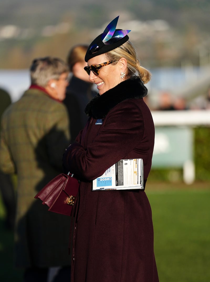 Zara Tindall, wearing a burgundy coat and navy hat, attends Cheltenham Racecourse on January 29, 2022. PA Wire