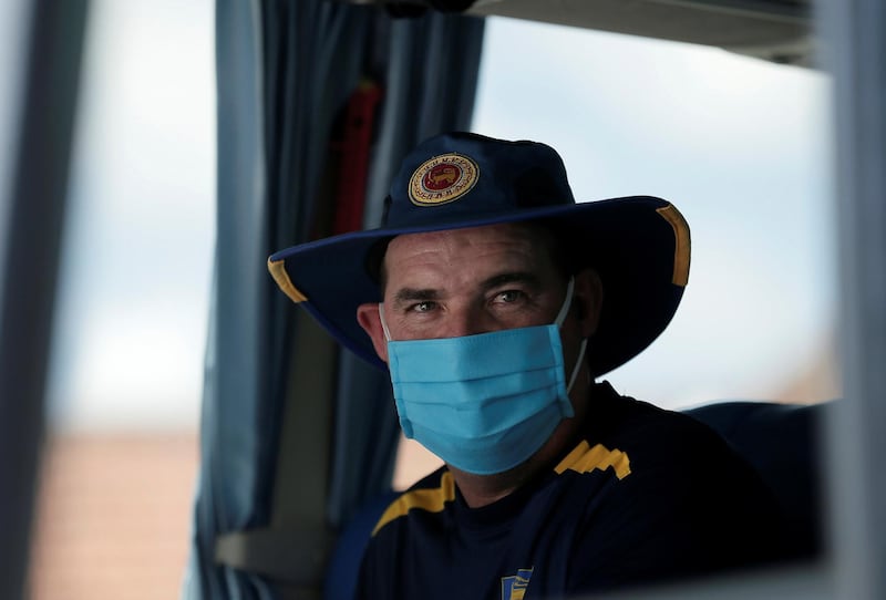 Sri Lankan national cricket team coach Mickey Arthur wearing a protective mask looks on from inside the team bus. Reuters