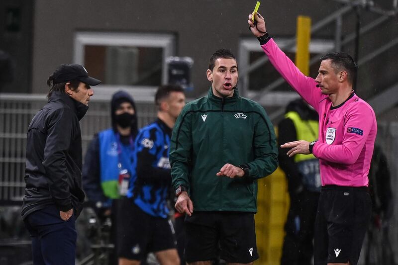 Referee Slavko Vincic shows a yellow card to Inter Milan manager Antonio Conte. AFP