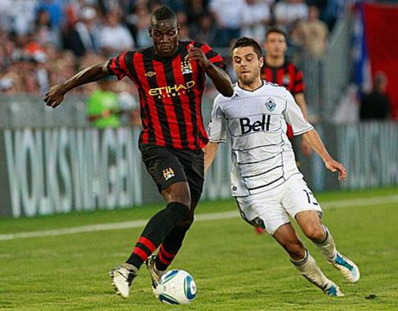 Mario Balotelli, left,  holds of Michael Nanchoff, of the Vancouver Whitecaps, during the friendly match on Manchester City’s tour of the United States.