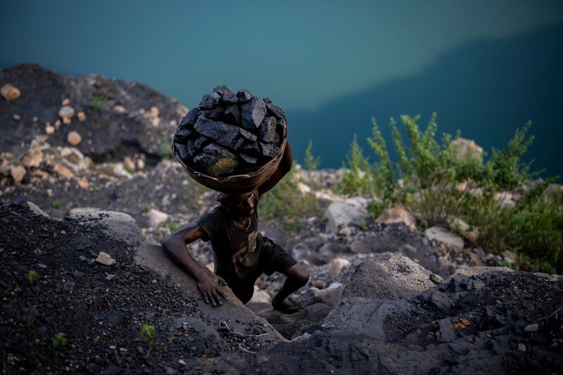 A man climbs a steep ridge with a basket of coal scavenged from a mine near Dhanbad, India, on September 24. AP Photo / Altaf Qadri