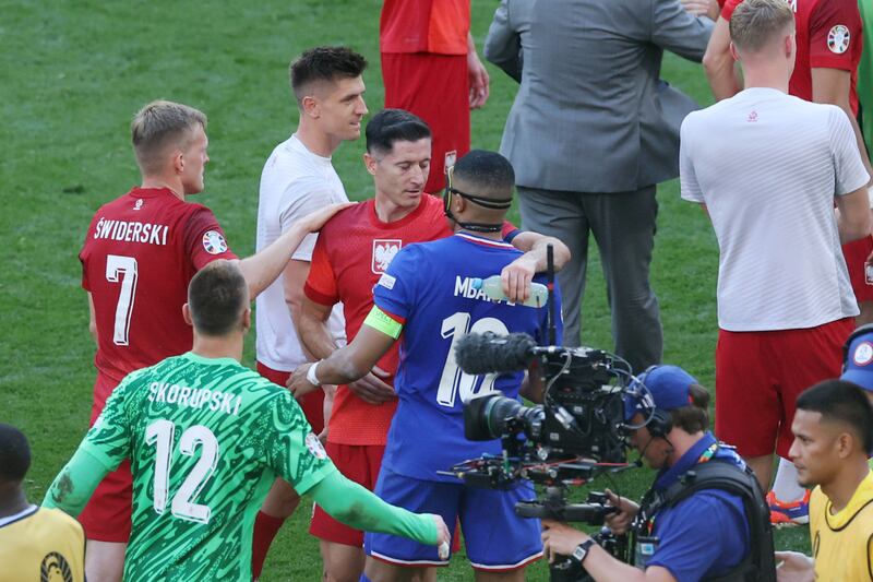 Robert Lewandowski of Poland with Kylian Mbappe of France after the match. Getty Images