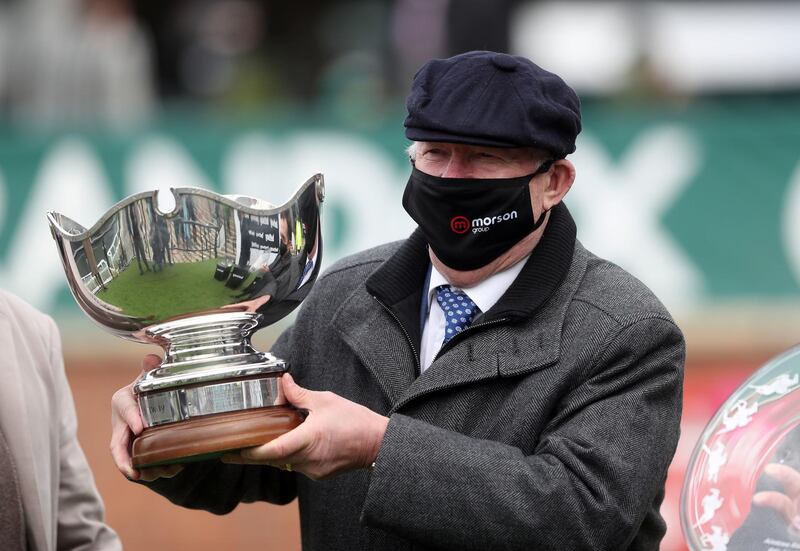 Alex Ferguson, owner of Clan Des Obeaux, collects the trophy after winning the Bowl Chase to complete a hat-trick of wins in the Grand National Festival at Aintree Racecourse. PA