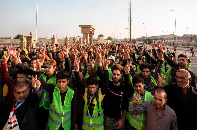 Iraqi protesters wearing yellow vests flash the victory gesture and shout slogans during a demonstration against corruption and lack of services in the southern city of Basra. AFP