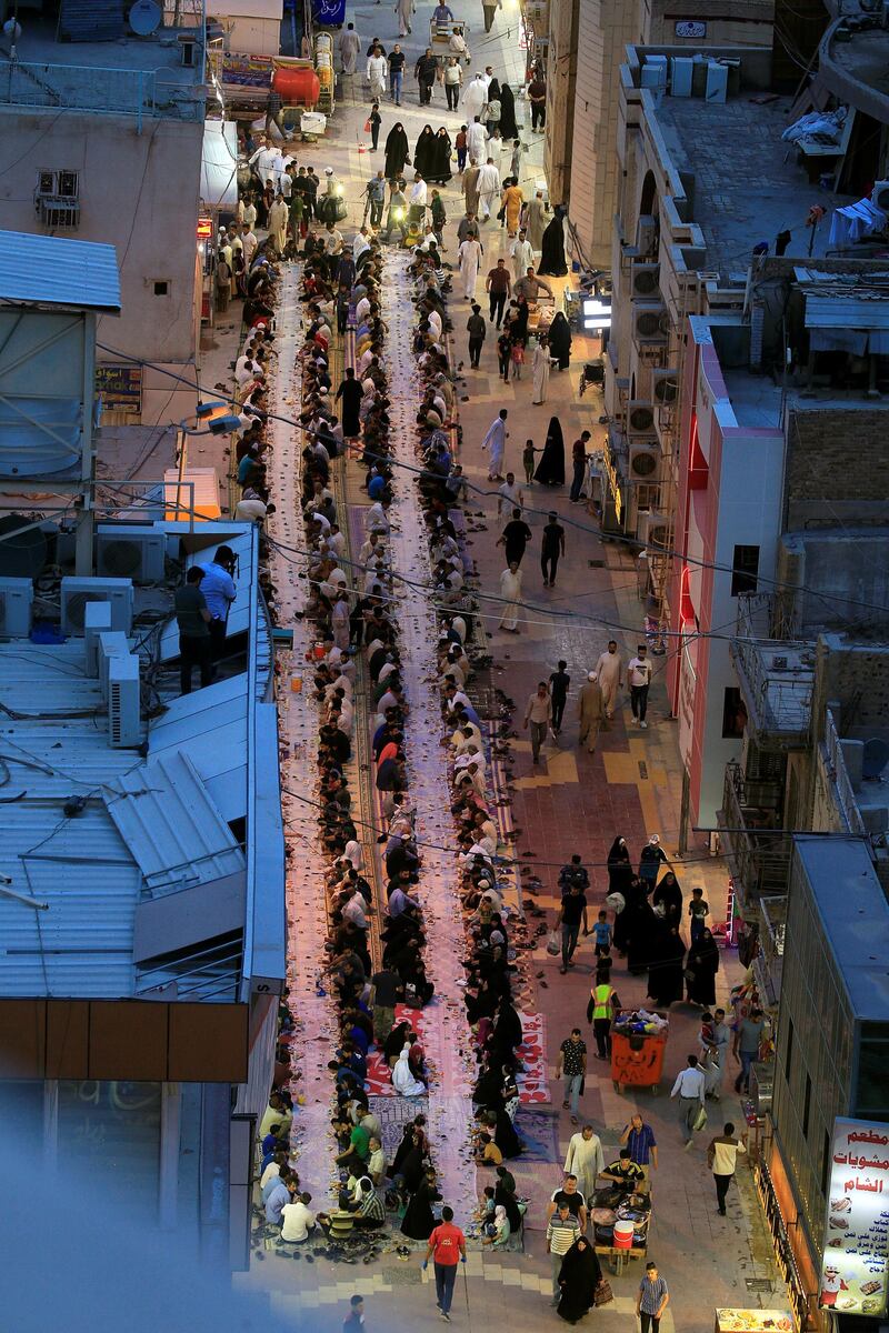 Iraqi Muslims wait to have their mass iftar 'break fasting meal' for free in a street during the holy month of Ramadan in the holy city of Najaf, Iraq.   REUTERS