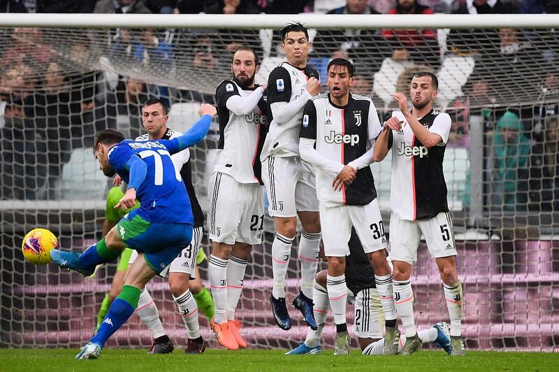 Sassuolo's Greek defender Giorgios Kyriakopoulos hits a free kick in front of a Juventus wall. AFP