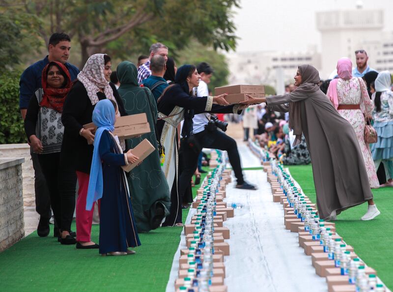 Jusoor volunteers distribute iftar meals at the mosque. Victor Besa / The National