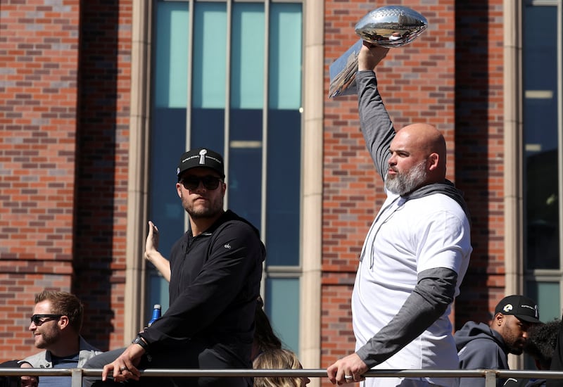 Los Angeles Rams player Matthew Stafford looks on as Andrew Whitworth holds the Vince Lombardi Trophy during the parade. Reuters
