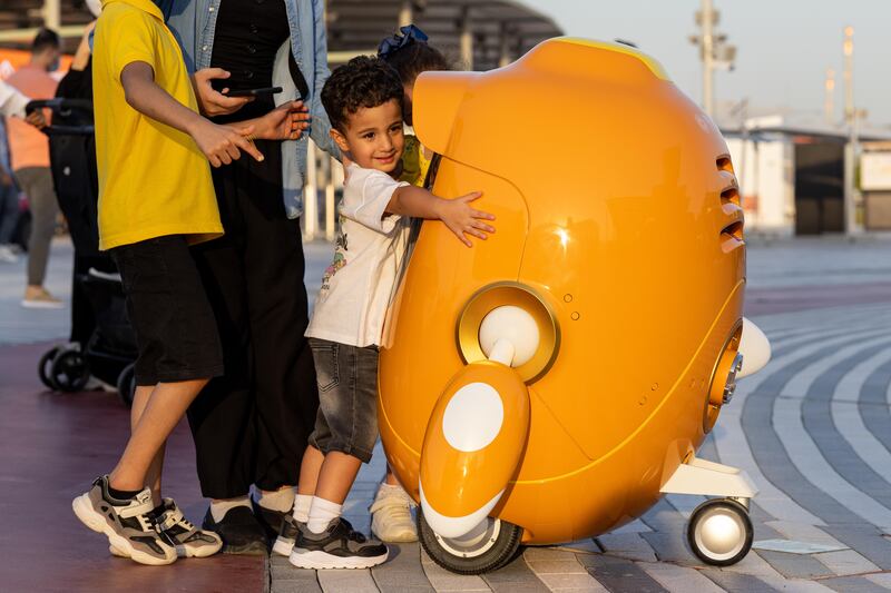 Kids interacting with one of the Opti robots in the Opportunity District. Image: Expo 2020 Dubai