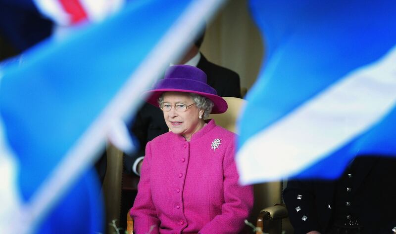 Queen Elizabeth is surrounded by Scottish flags as she watches the procession along the Royal Mile in Edinburgh to mark the formal opening of the Scottish Parliament in 2004. 