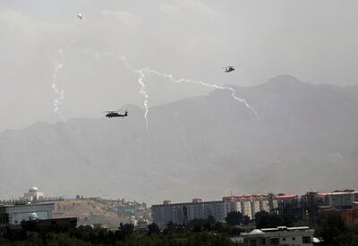 Anti-missile decoy flares are deployed as U. S.  Black Hawk military helicopters and a dirigible balloon fly over the city of Kabul, Afghanistan, Sunday, Aug.  15, 2021. AP