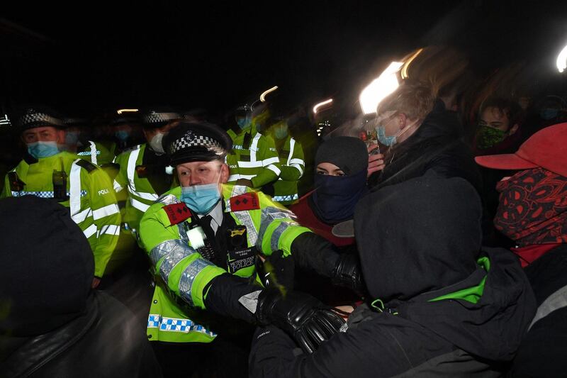 Police scuffle with people gathering at Clapham Common bandstand in London. AFP