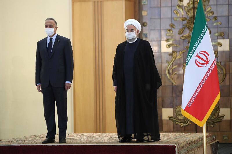 President Hassan Rouhani welcomes Iraqi Prime Minister Mustafa Al Kadhimi as they wear protective face masks, in Tehran, Iran. AP