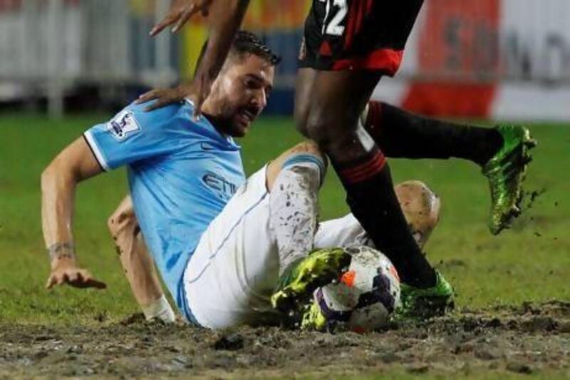 Manchester City's Javi Garcia, left, fights for the ball.