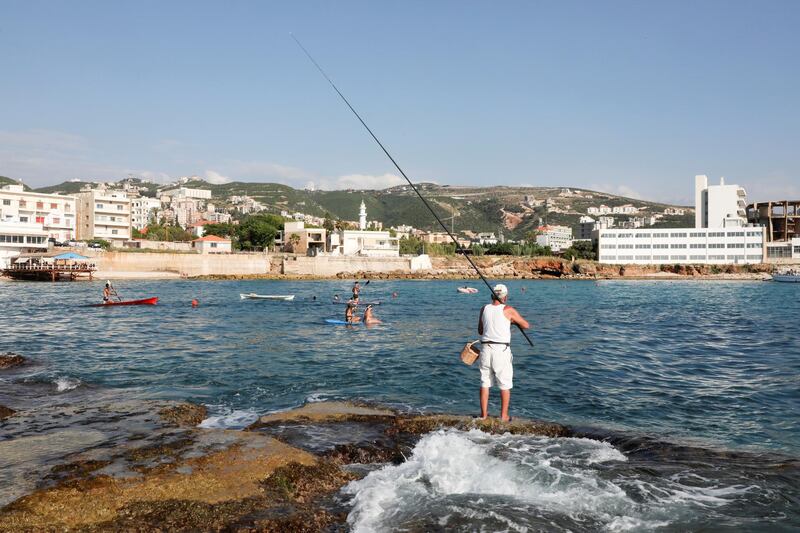 Elias Louka, 67, a retired chef, tries his luck fishing for the pot on a beach in Batroun, Lebanon. Reuters