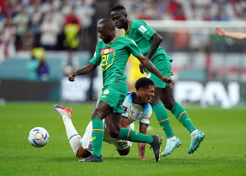England's Jude Bellingham is challenged by Senegal's Youssouf Sabaly. PA