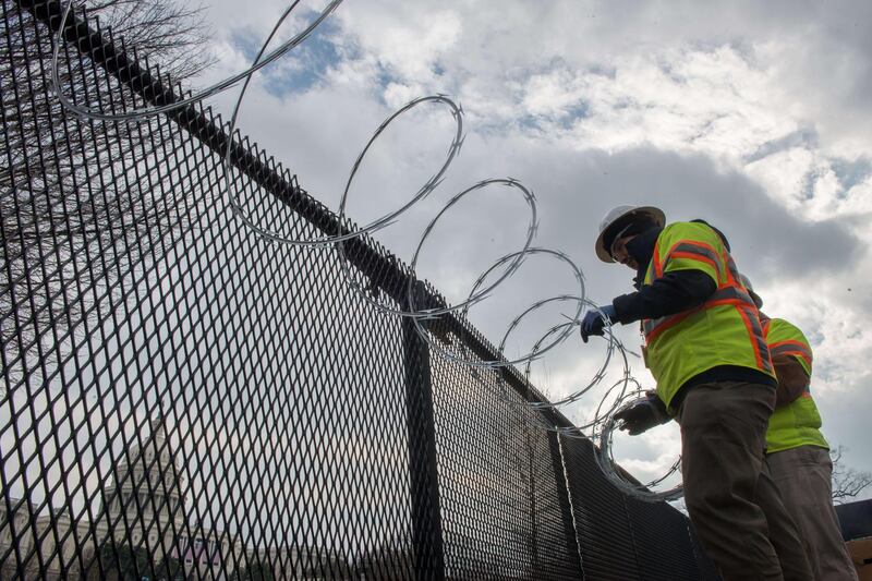 WASHINGTON, DC - JANUARY 15: Crews install razor wire on top of the fencing that now surrounds the US Capitol ahead of the inauguration on January 15, 2021 in Washington, DC. After last week's Capitol Riot the FBI has warned of additional threats against the US Capitol and in all 50 states.   Liz Lynch/Getty Images/AFP
== FOR NEWSPAPERS, INTERNET, TELCOS & TELEVISION USE ONLY ==
