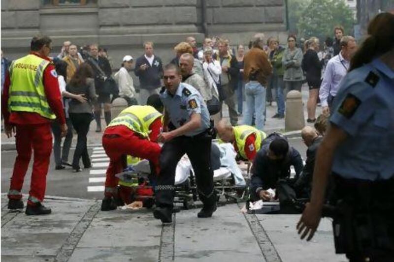 Rescue officials tend to a wounded man after a powerful explosion rocked central Oslo on 22.