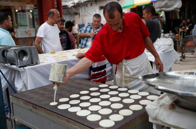 A vendor prepares sweets, qatayef, a pancake-like shell which is filled with nuts or sweet cheese, fried in oil or baked then dipped in sugar syrup, a popular sweet during Ramadan at the main market of Shijaiyah neighbourhood in Gaza City. AP Photo