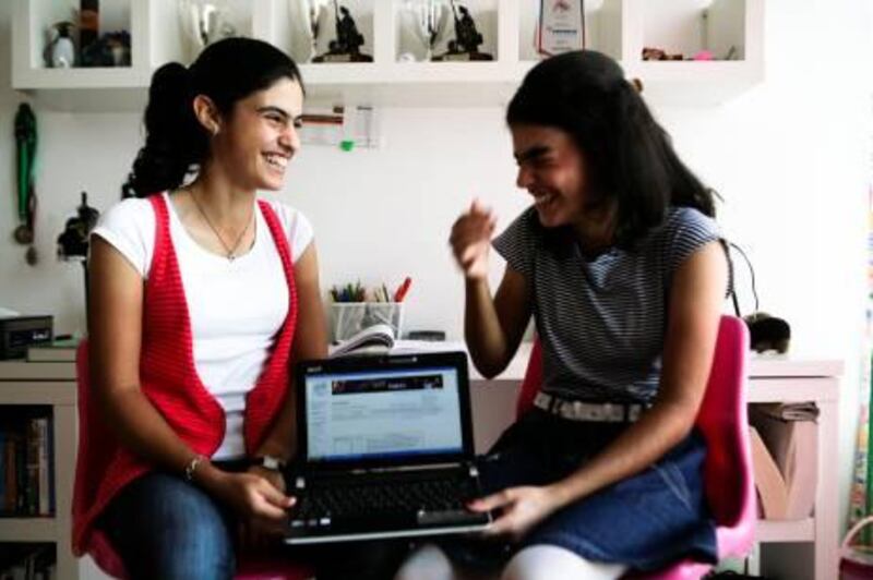 October 24, 2011, Dubai, UAE:

Boushra (left), 15, and Line Dalile(right), 14, have just passed their TOEFL proficiency exams. The girls have also already lectured at a TED conference and are currently eyeing university. They managed to do all of this on their own, using each other and online courses as their sole teachers. 

They are seen here in the bedroom they share, holding Boushra's laptop, which has her online TOEFL degree on the screen.
Lee Hoagland/The National