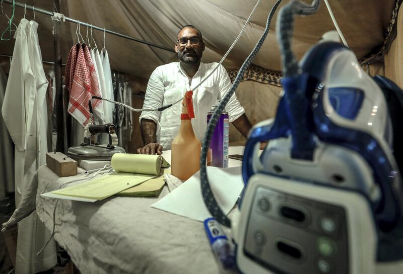 Abu Dhabi, United Arab Emirates, December 10, 2019.  
  -- Etisham Ahmed presses 50 conduras a day at a tent pop-up of Red Robe Laundry at the Al Dhafra Festival.
Victor Besa/The National
Section:  NA
Reporter:  Anna Zacharias