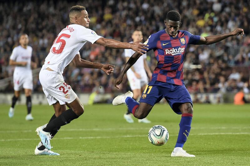 Sevilla's Brazilian midfielder Fernando (L) vies with Barcelona's French forward Ousmane Dembele during the Spanish league football match between FC Barcelona and Sevilla FC at the Camp Nou stadium in Barcelona on October 6, 2019. (Photo by Josep LAGO / AFP)