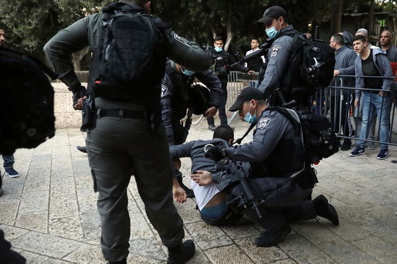 Israeli police officers detain a Palestinian man who tried to break through a security barrier to enter the the closed al-Aqsa mosque compound which remains shut to prevent the spread of coronavirus, in Jerusalem, Sunday, May 24, 2020. Muslims worldwide are marking a muted religious festival of Eid al-Fitr, the end of the fasting month of Ramadan. (AP Photo/Mahmoud Illean)