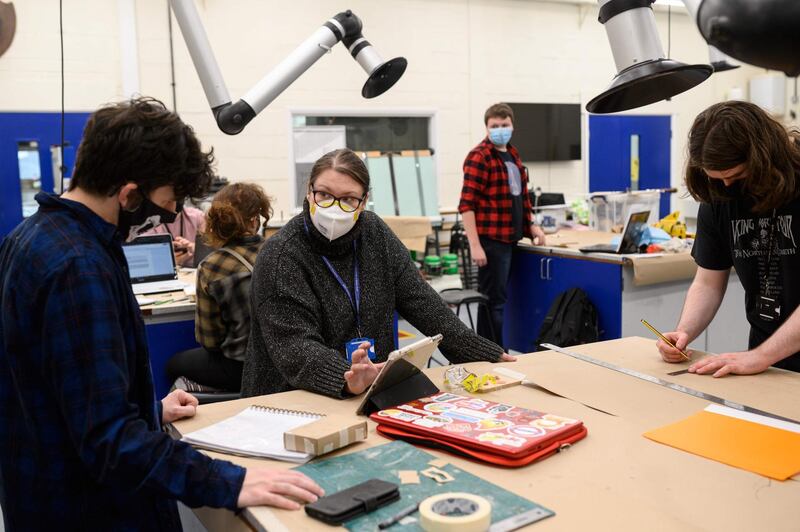 Lecturer in Prop Making, Miriam Hammond, instructs third year students on the Special Effects Model Making for Film and Television course as they wear face coverings during class at the University of Bolton, in Bolton. Oli Scarff / AFP