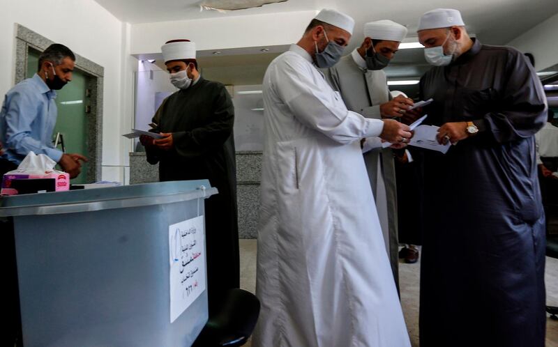 Muslim clerics gather before voting at a polling station in the Syrian capital Damascus. AFP