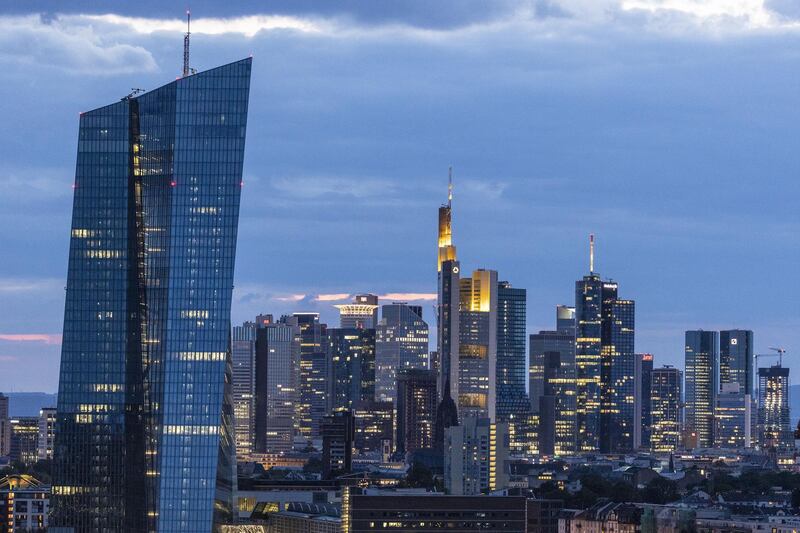 Skyscrapers including the headquarters of the European Central Bank (ECB), left, Commerzbank AG, center, and twin tower headquarters of Deutsche Bank AG, right, stand illuminated at dusk in the financial district in Frankfurt, Germany, on Tuesday, Aug. 13. 2019. Germany’s economy shrank in the second quarter, ramping up pressure on Chancellor Angela Merkel to unleash fiscal stimulus as manufacturers reel from a U.S.-China trade war. Photographer: Alex Kraus/Bloomberg